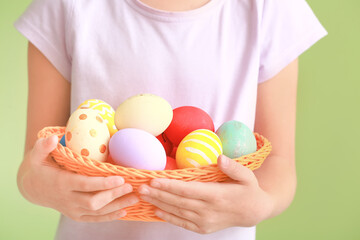 Fototapeta na wymiar Cute little girl with Easter eggs on color background, closeup