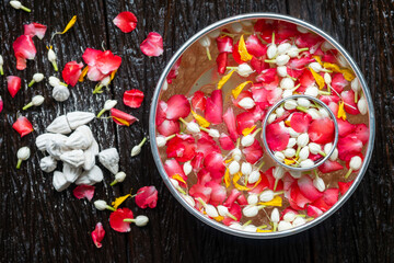 Roses, jasmine and marigolds In a large silver bowl on a wooden floor , Songkran Festival or Thai New Year