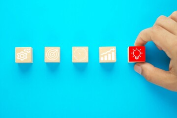 Business process management, Businessman plan a project with wooden cubes with icon business strategy on blue background. 

