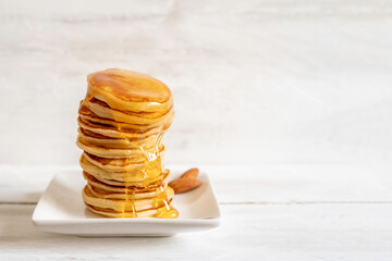 Pancakes with honey on white background with copy space.
 