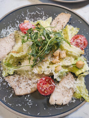 Close-up of caesar salad with chicken fillet and parmesan cheese.