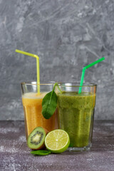 Two tall glasses of orange juice and a banana-orange kiwi and spinach smoothie