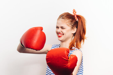 Strong woman are engaged in boxing in red gloves on a light background aggression emotions