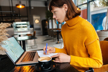 Attractive girl student studying online from her laptop