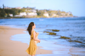 Fototapeta na wymiar Girl wearing yellow dress at Diamond Head Beach Park , Honolulu Oahu Hawaii