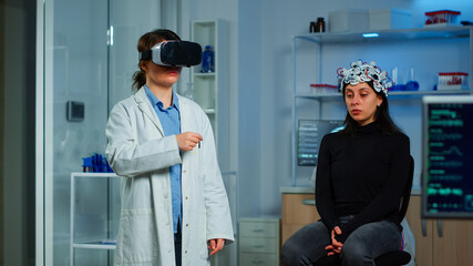 Professional researcher wearing virtual reality glasses using medical inovation in lab analysing brain scan of patient. Team of neurological doctors working with equipment high tech simulator device