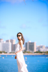 Fototapeta na wymiar Girl wearing white long dress by the sea, Honolulu, Oahu, Hawaii