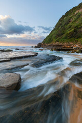 Fototapeta na wymiar Sea water flowing around rock formation on the shore.