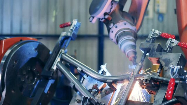Robotic arm welding a bicycle frame at factory