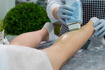 Beauty and Healthcare. Close-up Of A Beautician Doing Depilation With Hot Wax On Woman`s Leg Using Wax Device In Spa.