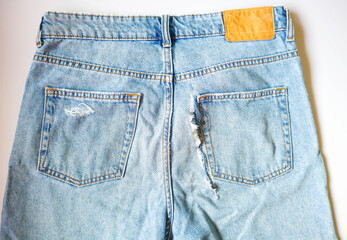 Torn blue jeans at bottom on white background