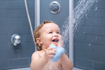 Happy funny baby bathed in the bath. Child in shower.