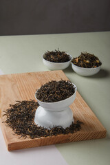 Chinese tea FROM A FOGGY MOUNTAIN. Dry loose Chinese tea leaves on wooden background. Space for text.