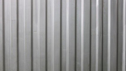 Gray painted metal corrugated sheet fence surface vertical lines industrial texture background