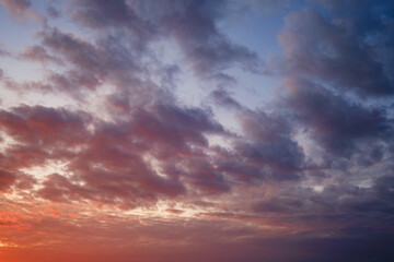 Naklejka na ściany i meble Calm sea with sunset sky and sun through the clouds over.