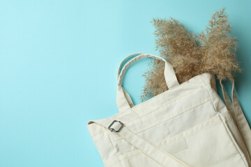 Stylish eco bag with reeds on blue background