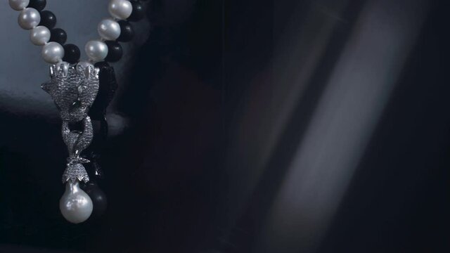 Beautiful pearl necklace rotating on black background
