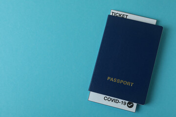 Passport with ticket and Covid - 19 mark on blue background
