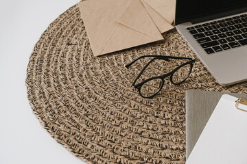 Home office workspace with laptop, glasses, clipboard pad, envelopes. Minimalist work, business...