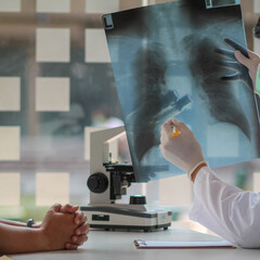 Doctors are examining X-rays of the patient's chest and pinpointing the site of malignant lung...