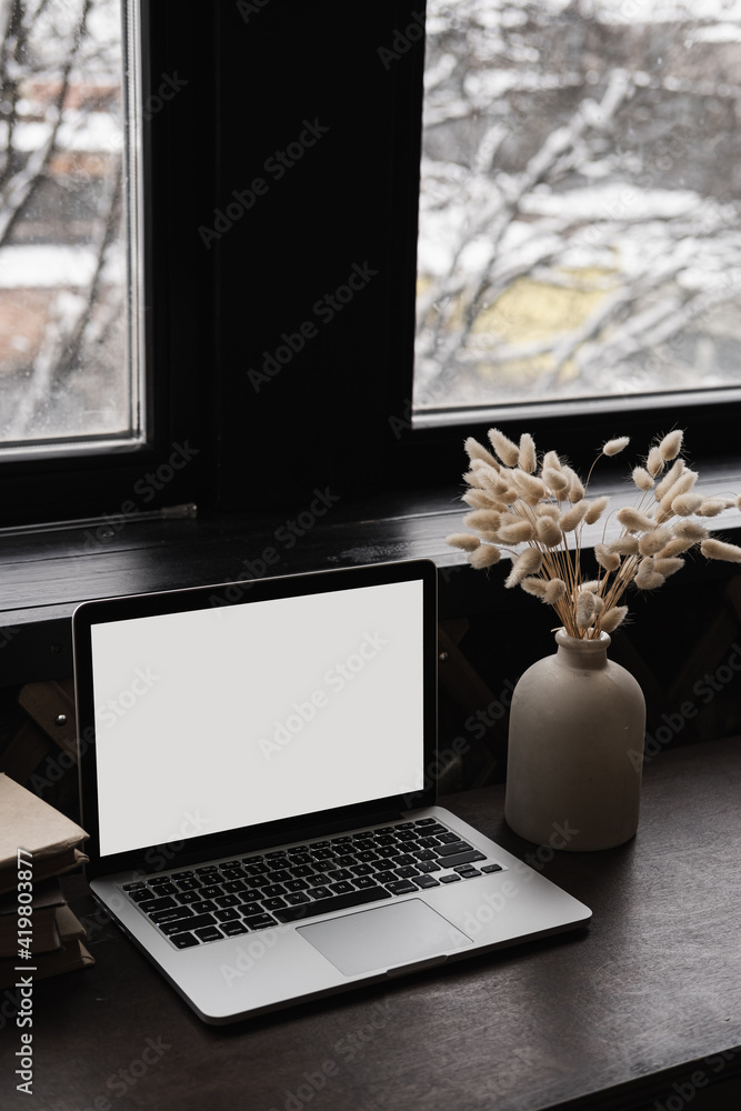 Wall mural laptop computer with blank screen on table with books stack, bunny rabbit tail grass bouquet. aesthe