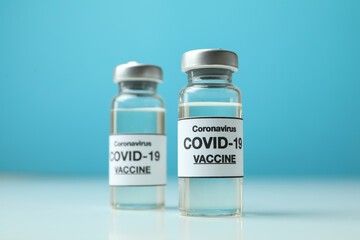 Vials of Covid - 19 vaccine against blue background