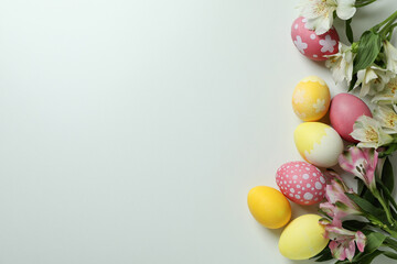 Fototapeta na wymiar Color Easter eggs and alstroemeria flowers on white background