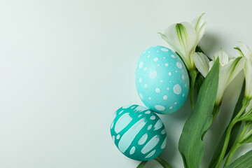 Color Easter eggs and alstroemeria flowers on white background