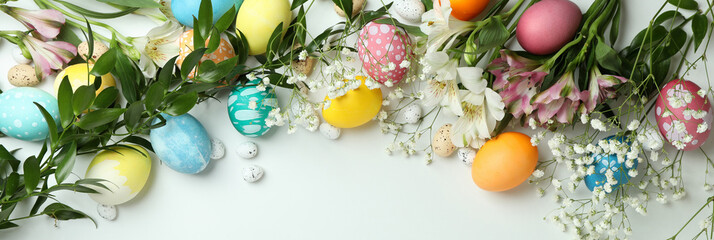 Fototapeta na wymiar Easter eggs and beautiful flowers on white background, top view