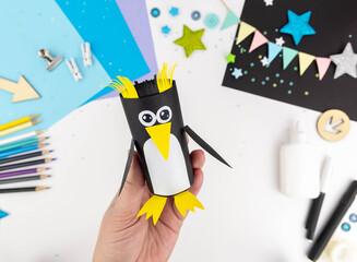 Step-by-step instructions for making a penguin with children from a toilet roll of paper and...