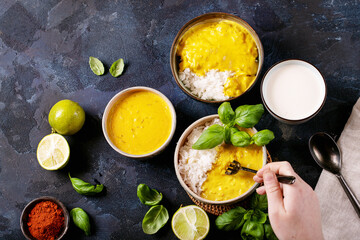 Female holding ceramic bowl of yellow curry