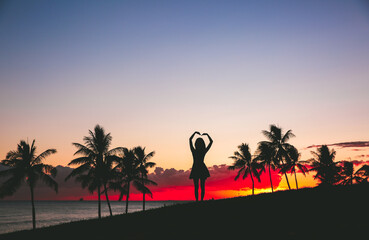 Girl by the seas at sunset, palm trees silhouette beautiful sky, Kakaako Waterfront Park, Honolulu, Oahu, Hawaii
