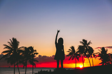 Girl by the seas at sunset, palm trees silhouette beautiful sky, Kakaako Waterfront Park, Honolulu, Oahu, Hawaii
