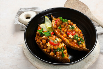 Stuffed sweet potato with spiced chickpea, dressing and herbs.