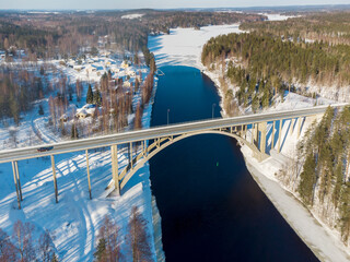 Long arch bridge over the stream in winter 