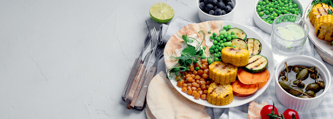 Delicious grilled vegetables with sauces and snacks served on light gray background.
