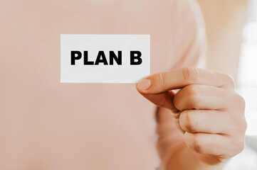 Man holding a business card with PLAN B