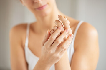 Young beauty woman applying moisturizer on hands