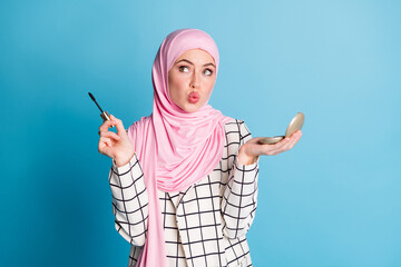 Portrait of pretty funky flirty muslimah girl holding in hands mirror mascara pout lips isolated...