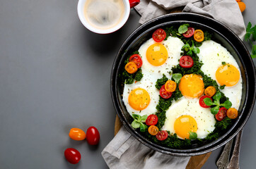 Fried eggs in frying pan for breakfast. Grey background