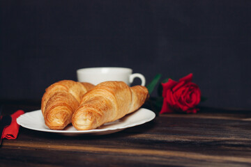 croissants on a plate a cup of coffee wooden table dessert
