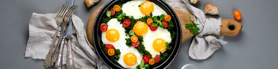 Fried eggs in frying pan for breakfast. Grey background