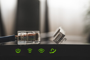 Close up shot of internet router and green icons of WIFI connection. Internet cable on router