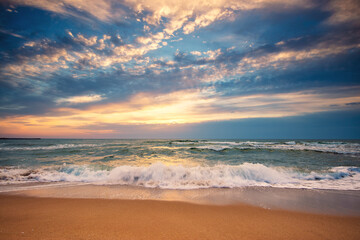 Fototapeta na wymiar Beach sunrise over the sea and dramatic clouds