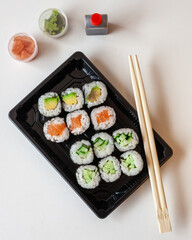 Top down view of fresh take away sushi on a white background with copy space