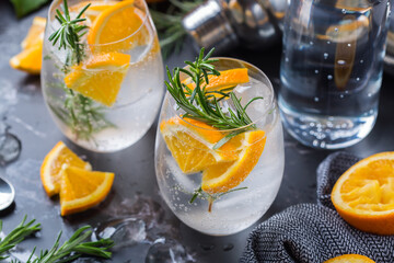 Hard seltzer cocktail with orange, rosemary and bartenders accessories