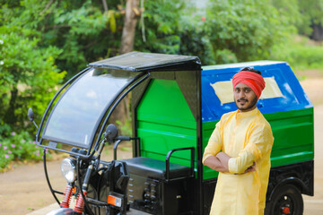 Young indian man standing with garbage van