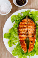Grilled salmon steak put on green vegetable taken from top view