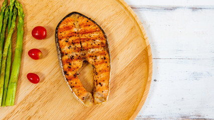 Grilled salmon steak served with asparagus and lemon taken from top view