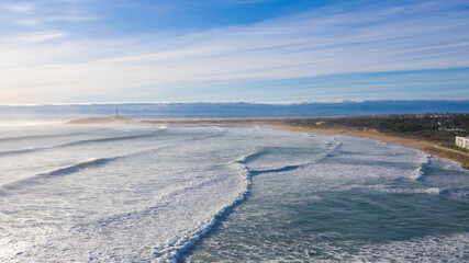 Aerial drone view of the Cape of Trafalgar with surfer waves breaking on the bay at the Atlantic Ocean in south Spain